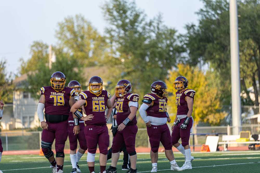 Trojan football team in a huddle before a play